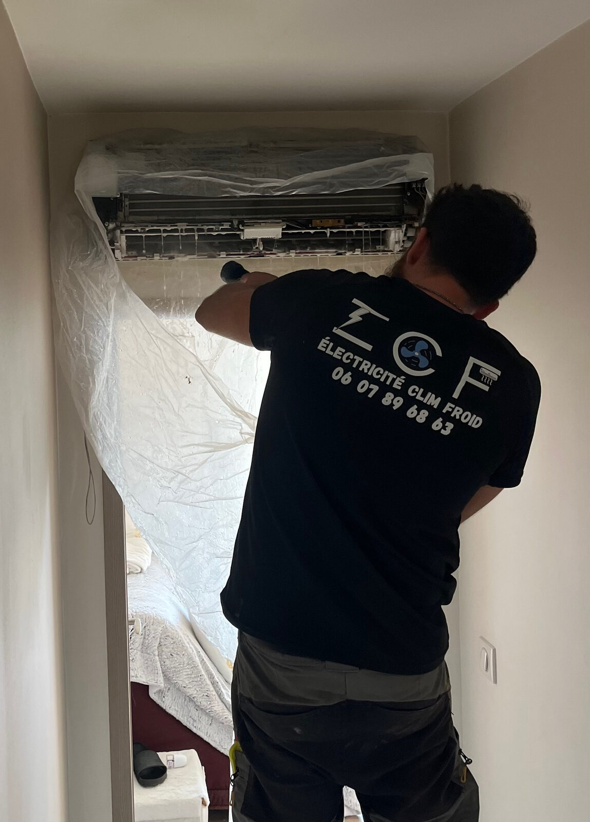 Technicien ECF en train d'installer un climatiseur mural